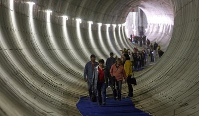 Interessierte Bürger laufen in Leipzig durch die erste fertige Tunnelröhre des Leipziger City-Tunnels. Die Eröffnung wird sich um ein weiteres Jahr verzögern. (FOTO: DPA)