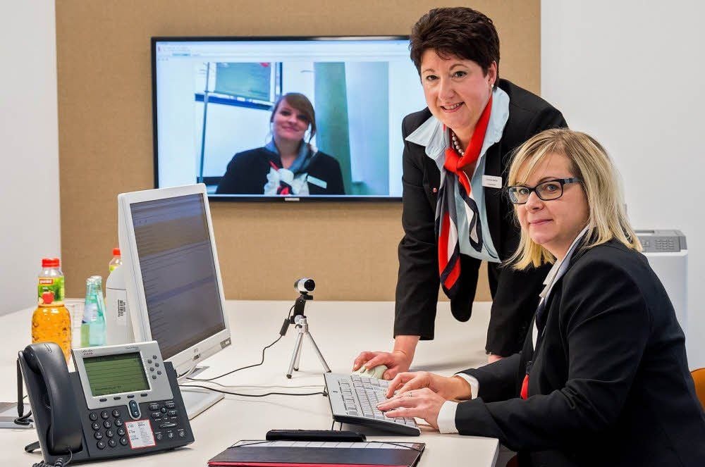 Niederlassungsleiterin Christina Herbst (M.) und Filialleiterin Anja Schuster bei einer Videotelefonie mit ihre Kollegin Katja Bier.