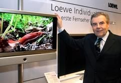 Rainer Hecker, Vorstandschef des TV-Geräte-Herstellers Loewe AG (Kronach), steht vor dem neuesten Modell eines Flachbildschirms. (Foto: dpa)