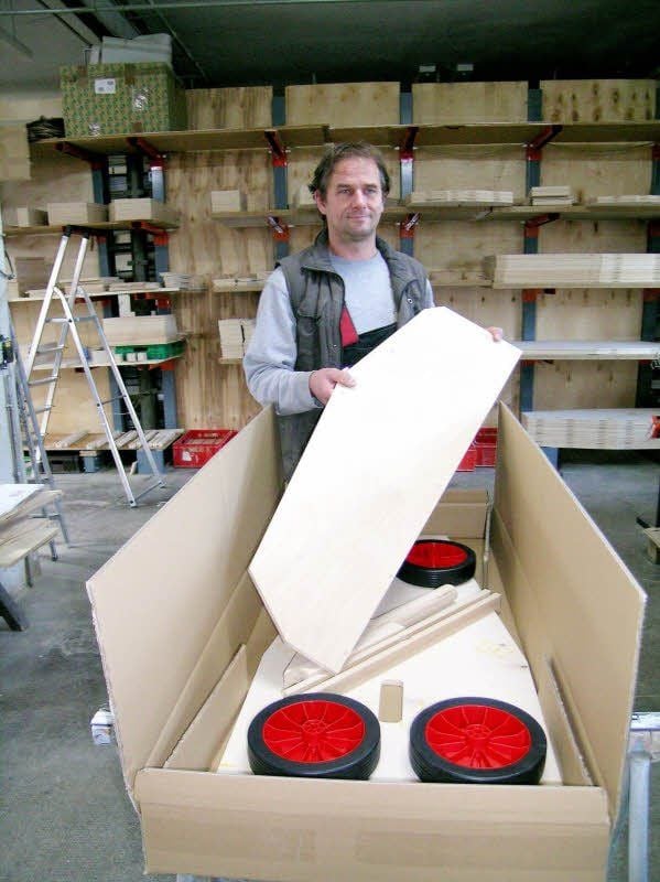 Frank Niehle verpackt einen Bausatz für Seifenkisten. In dem kleinen Betrieb muss jeder alles machen.