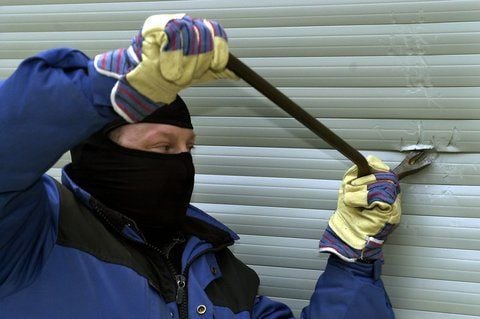 Ein Einbrecher versucht mit einem Stemmeisen einen Rolladen aufzuhebeln. (SYMBOLFOTO: DPA)