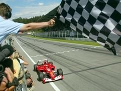 Der deutsche Formel 1-Weltmeister Michael Schumacher (Ferrari) fährt am Sonntag (18.05.2003) auf dem A1-Ring in Spielberg/Österreich nach seinem Sieg beim Großen Preis von Österreich über die Ziellinie. (Foto: dpa)
