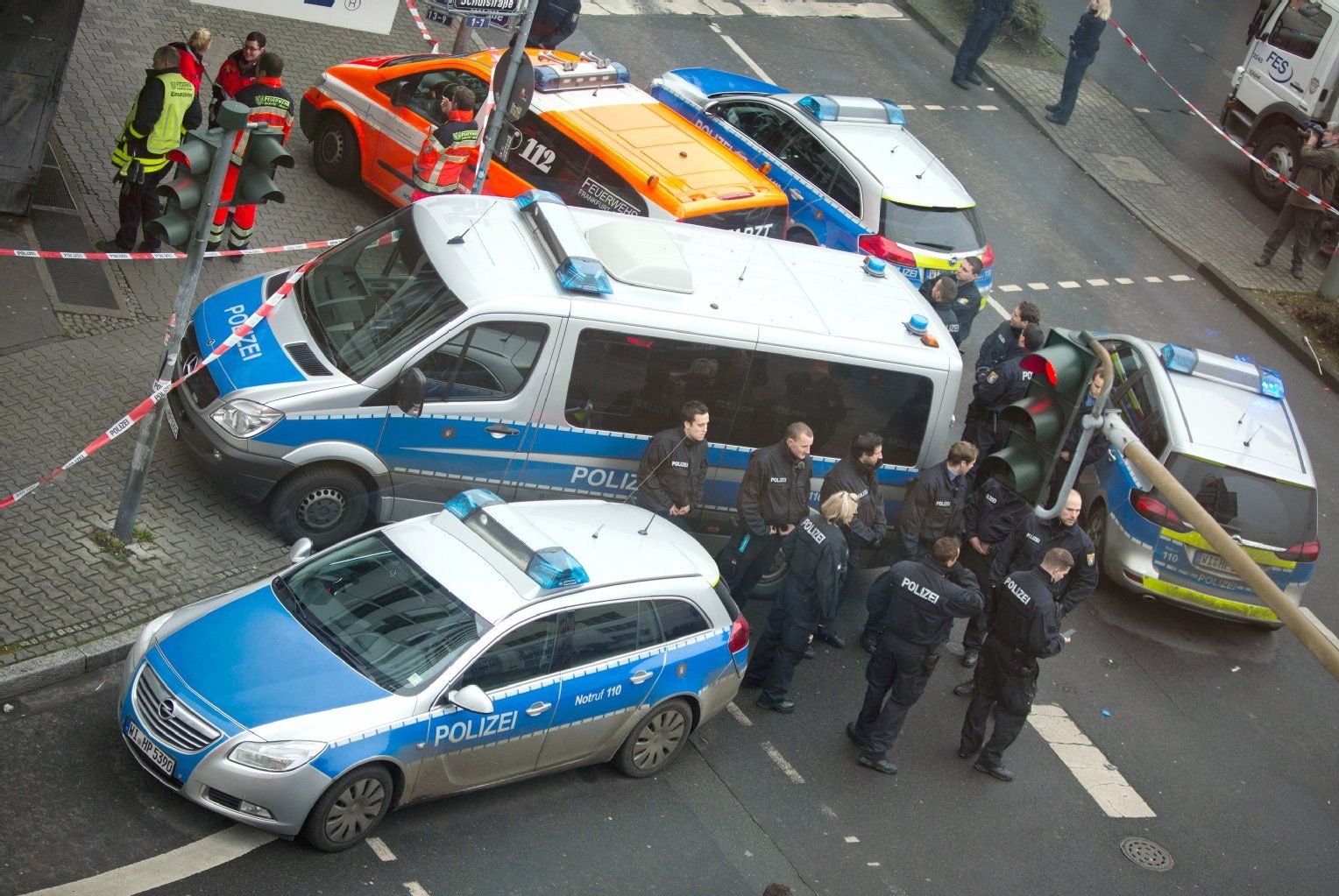 Polizisten und ihre Fahrzeuge stehen am 03.01.2014 in Frankfurt am Main (Hessen) vor einem Büro- und Ärztehaus im Stadtteil Sachsenhausen, wo am Freitagvormittag die Leiche eines Mannes gefunden wurde.