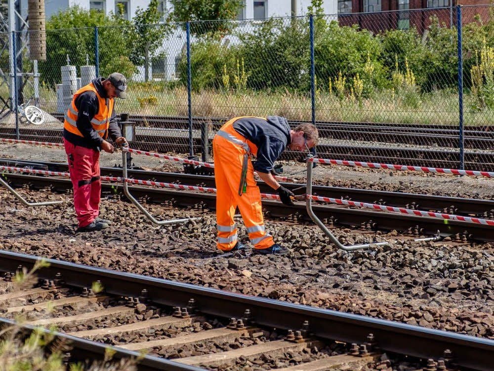 Am Bahnübergang Heuweg sind Arbeiter dabei, die Strecke zu sichern. Heute beginnen die Bauarbeiten.