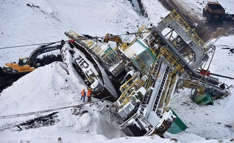 Arbeiter stehen am 22. Januar neben einem verunglückten Schaufelradbagger im Tagebau Vereinigtes Schleenhain bei Deutzen (Sachsen). (FOTO: DPA)