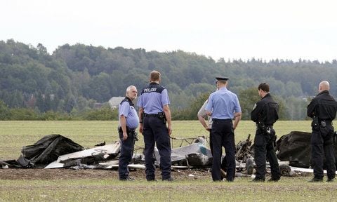 Polizisten stehen im mittelsächsischen Halsbrücke bei Freiberg neben dem Wrack eines Leichtflugzeuges, das am Montagmorgen abgestürzt war. (FOTO: DPA)