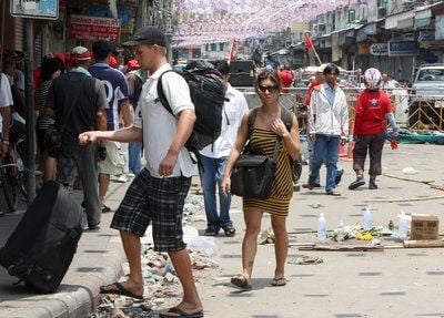 Ausländische Touristen laufen ihrem Gepäck durch Bankok. (FOTO: DPA)