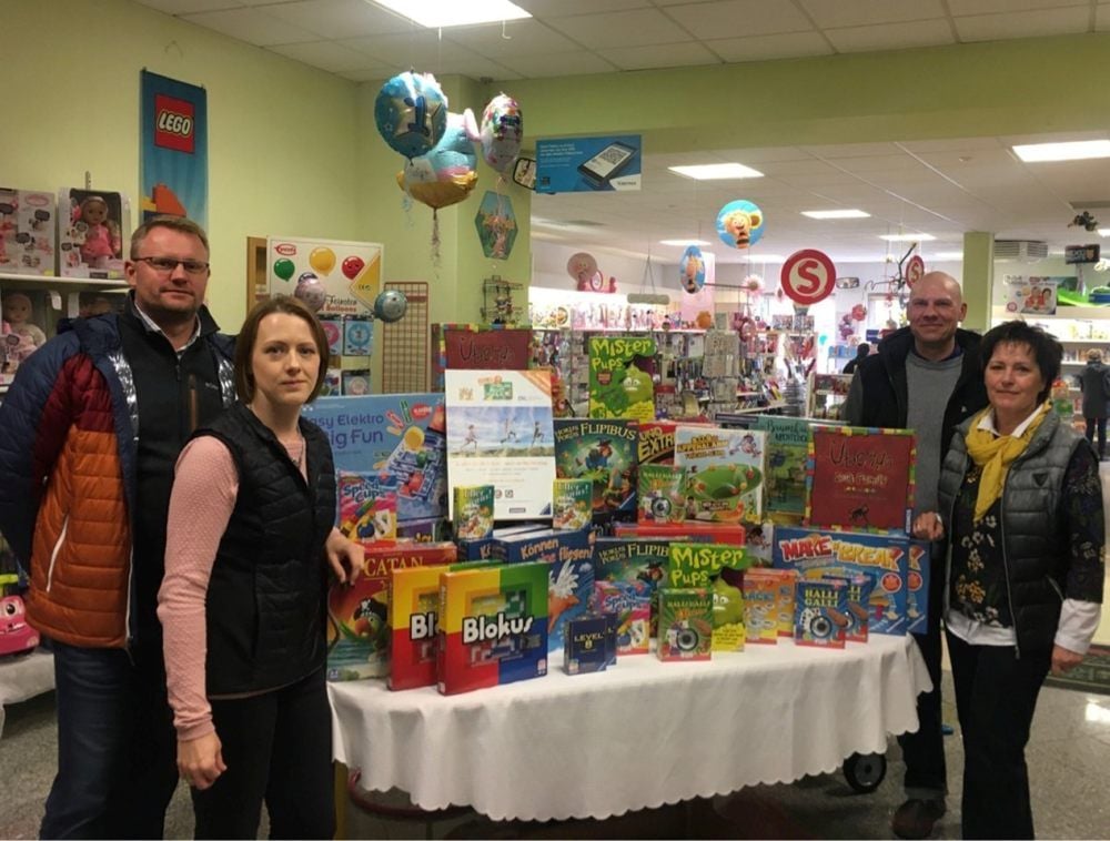 Ballenstedts Bürgermeister MIchael Knoppik (li.) und Christian Krause (2. von re.) vom Hort I, Brinckmeier Grundschule in Ballenstedt haben das Spielepaket von Julia und Heike Lohmann überreicht bekommen.