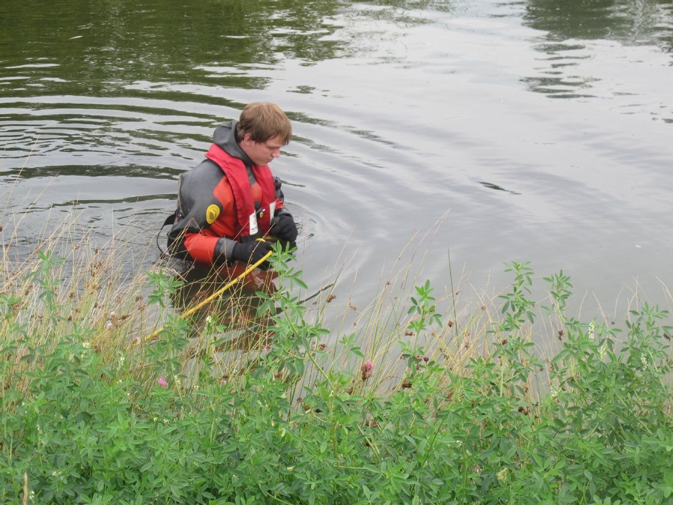Einsatzkräfte der DLRG suchen einen Teich in Halle-Neustadt ab