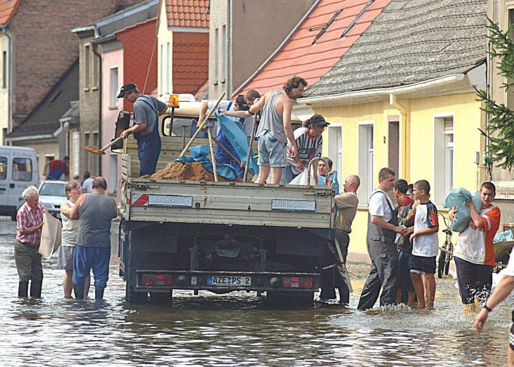 Das Hochwasser 2002 steht in der Roßlauer Straße Am Schlossgarten. Unternehmer Andreas Thauer hatte Sand angefahren, die Sandsäcke wurden gleich von der Ladefläche aus befüllt.
