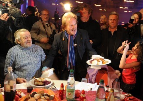 Der Sänger Frank Zander (M) serviert am Dienstag in Berlin-Neukölln im Hotel Estrel beim traditionellen Weihnachtsessen für Menschen von der Straße Gänsebraten. (FOTO: DPA)