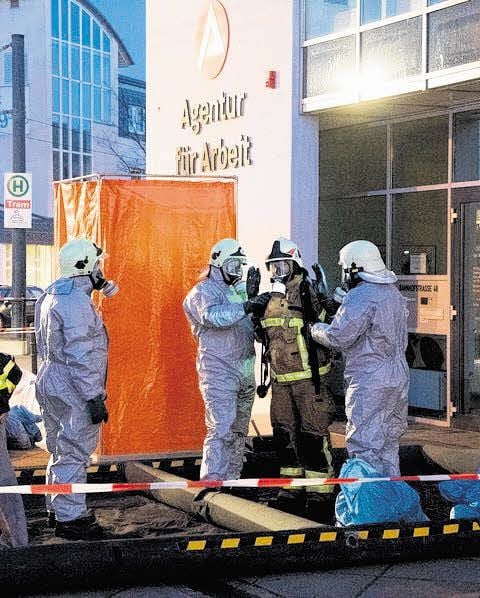 Die Einsatzkräfte werden aus ihren Schutzanzügen befreit.