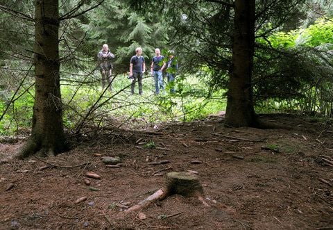 An dieser Stelle in einem Waldstück bei Holdorf (Kreis Vechta) nahmen sich drei jungen Frauen gemeinsam das Leben. Im Hintergrund sind Medienvertreter zu sehen, die sich an dem Fundort umsehen. (FOTO: DPA)