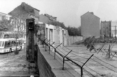 Blick auf die Berliner Mauer mit Sperranlagen und Todesstreifen in der Bernauer Straße in Berlin-Wedding. Gut zu erkennen sind auch noch die Reste der Häuser die nach und nach für den Mauerbau abgerissen wurden. (FOTO: ARCHIV/DPA)