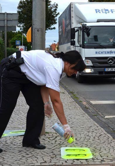 Christine Brenning sprüht an der Fußgängerampel in der Friedensstraße.