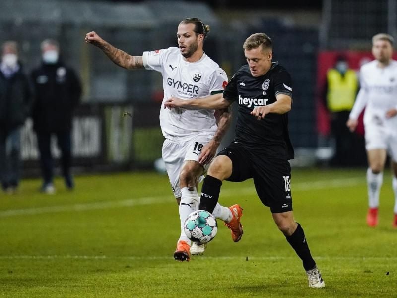 Sandhausens Dennis Diekmeier (l) und Felix Kroos von Eintracht Braunschweig kämpfen um den Ball. Foto: Uwe Anspach/dpa