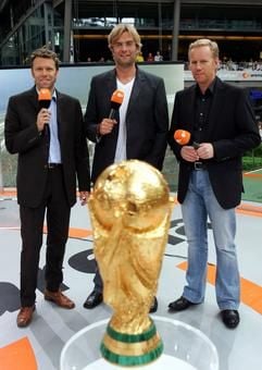 ZDF-Moderator Johannes B. Kerner (r.), Urs Meier, langjähriger FIFA-Schiedsrichter aus der Schweiz und Jürgen Klopp (M.), Cheftrainer des 1. FSV Mainz 05, stehen im WM-Studio im Sony Center am Potsdamer Platz hinter einer Kopie des FIFA WM-Pokals. (Foto: dpa)