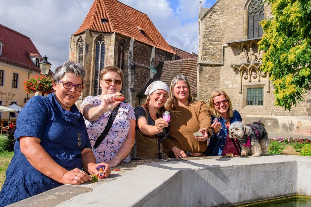 Melanie Specht (M.) und Susann Anders (2.v.r.) haben die Uta-Stein-Aktion ins Leben gerufen - hier an der Seite der Mitglieder der Facebook-Gruppe Dorit Schnürpel (l.), Christel Stoye und Heike Knörrich (r.). Am Brunnen auf dem Domplatz wurde der erste bunte Stein abgelegt.