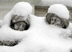 Zwei Steinfiguren sitzen im Wiesbadener Stadteil Mainz-Kastel tief verschneit auf ihrer kalten Steinbank. Heftiger Schneefall bestimmte das Wetter in weiten Teilen Deutschlands. (Foto: dpa)