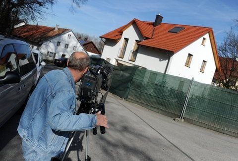 Ein Kameramann filmt in Notzing (Oberbayern) ein Wohnhaus, in dessen Garten zwei Leichen gefunden wurden. (FOTO: DPA)