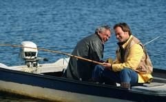 Germain Lesage (gespielt von Raymond Bouchard) und Christopher Lewis (David Boutin) sitzen in einer Jolle und angeln (Szenenfoto). Das winzige Inseldorf Sainte-Marie-La-Mauderne hat schwer zu kämpfen: Die Fischgründe sind erschöpft und immer mehr Fischer werden arbeitslos. Ein Industrieunternehmen stellt in Aussicht, sich in dem Dorf niederzulssen. Bedingung dafür ist aber ein Arzt vor Ort. Und so versuchen die Einwohner von Sainte-Marie-La-Mauderne, angeführt von Lesage, der den Ersatz-Bürgermeister miemt, alles, um den Schönheitschirugen Lewis an das Dorf zu binden. Dem Regiedebütanten Jean-Francois Pouliot gelingt mit der «Der großen Verführung» eine warmherzige und bisweilen skurile Komödie. (Foto: dpa)