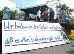 «Wir bedauern den Unfall und hoffen, dass es allen bald wieder gut geht» steht auf der Tafel, die am Montag (09.06.2003) auf dem Blücherplatz in Berlin steht. Bei schweren Unwettern war am Sonntagabend (08.06.2003) beim Karneval der Kulturen ein Gerüst umgestürzt und hatte mehrere Menschen unter sich begraben. Drei der Opfer wurden mit lebensgefährlichen Verletzungen ins Krankenhaus gebracht. Das Straßenfest wurde danach abgebrochen. (Foto: dpa)