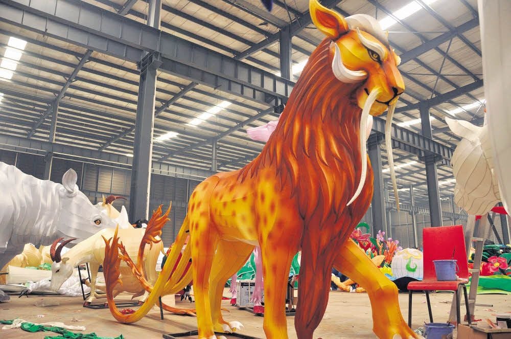 Noch werden die gigantischen Tier- und Fabelwesen aus Eisendraht und Seidenstoffen in einer großen Werkshalle in der chinesischen Provinz Sichuan von Künstlern zusammengebaut und bemalt.