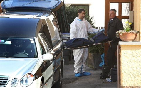 Mitarbeiter eines Bestattungsunternehmens tragen am in Krailling ein totes Kind auf einer Bahre aus einem Wohnhaus. (FOTO: DPA)