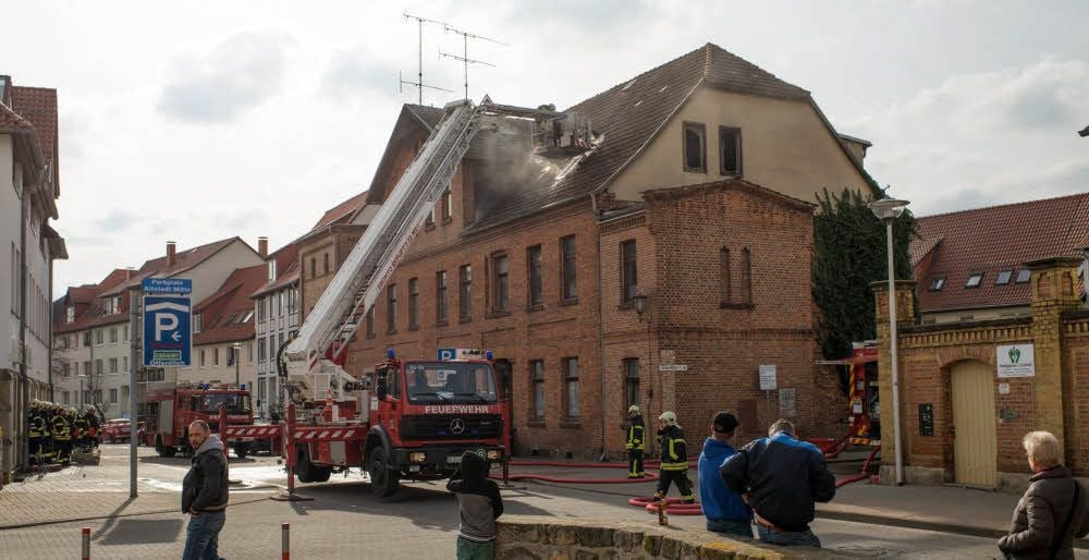 Feuerwehrleute drangen auch über Drehleiter und Dach zum Brandherd in der Wohnung vor.