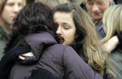 Den Schrecken vergessen oder ihn aufarbeiten? Zwei Schülerinnen umarmen sich vor der St. Pankratius Kirche in Emsdetten. (Foto: dpa)