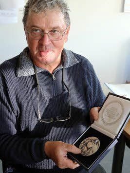 Gerhard Böhme zeigt die in Krumke erhaltene Medaille.