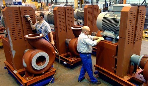 Zwei Mitarbeiter des Pumpenherstellers KSB AG montieren Abwasserasserpumpen in der Werkhalle des Unternehmens in Halle.