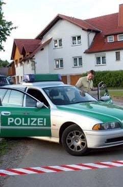 Ein Polizeibeamter steigt am Freitag (23.05.2003) im Vöhler Ortsteil Marienhagen (Kreis Waldeck-Frankenberg) vor dem Haus, in dem sich eine Familientragödie ereignet hat, in seinen Einsatzwagen. Die vierköpfige Familie eines Polizeibeamten ist in dem Haus tot aufgefunden worden. Beamte seiner Dienststelle fanden am Freitagnachmittag ihren 51-jährigen Kollegen, seine 48 Jahre alte Ehefrau und die beiden Söhne im Alter von 14 und 19 Jahren tot im Wohnhaus der Familie, teilte die Polizei in Kassel mit. Der Mann war am Morgen nicht zum Dienst bei der Polizeidirektion Korbach erschienen. (Foto: dpa)