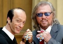 Die Bee Gees, Barry (r.) und Robin Gibb, halten ihre Orden in Händen, nachdem sie vom Prinzen von Wales zum Commander of the British Empire (CBE) ernannt worden sind. (Foto: dpa)