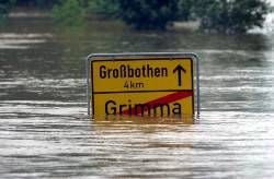 Das Ortsausgangsschild der sächsischen Stadt Grimma in Richtung Großbothen ist am 13. August 2002 nahezu vom Hochwasser des Flusses Mulde erreicht. Die Stadt Grimma war neben den Regionen Döbeln und der Stadt Waldheim einer der Schwerpunkte von Evakuierungen. (Archivfoto: dpa)