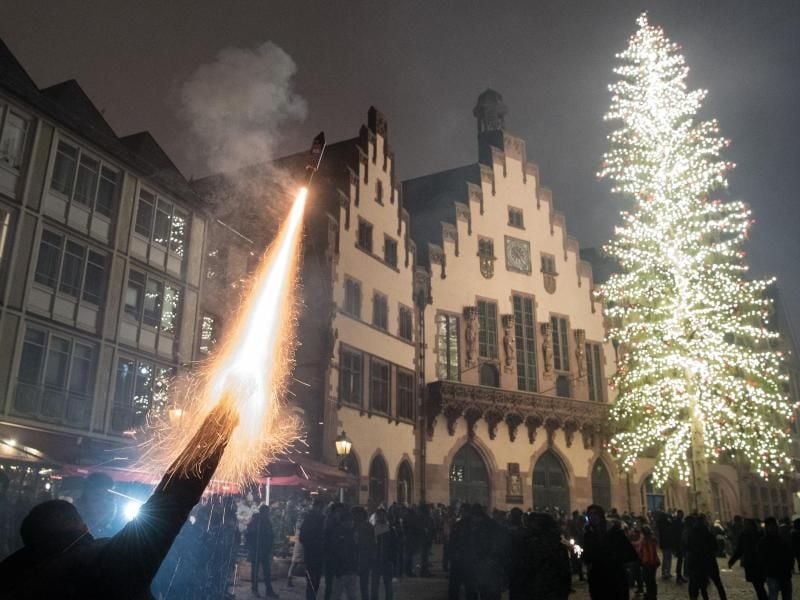 Eiun Mann feuert eine Silvesterrakete auf dem Römerberg in Frankfurt am Main ab. Foto: B. Roessler