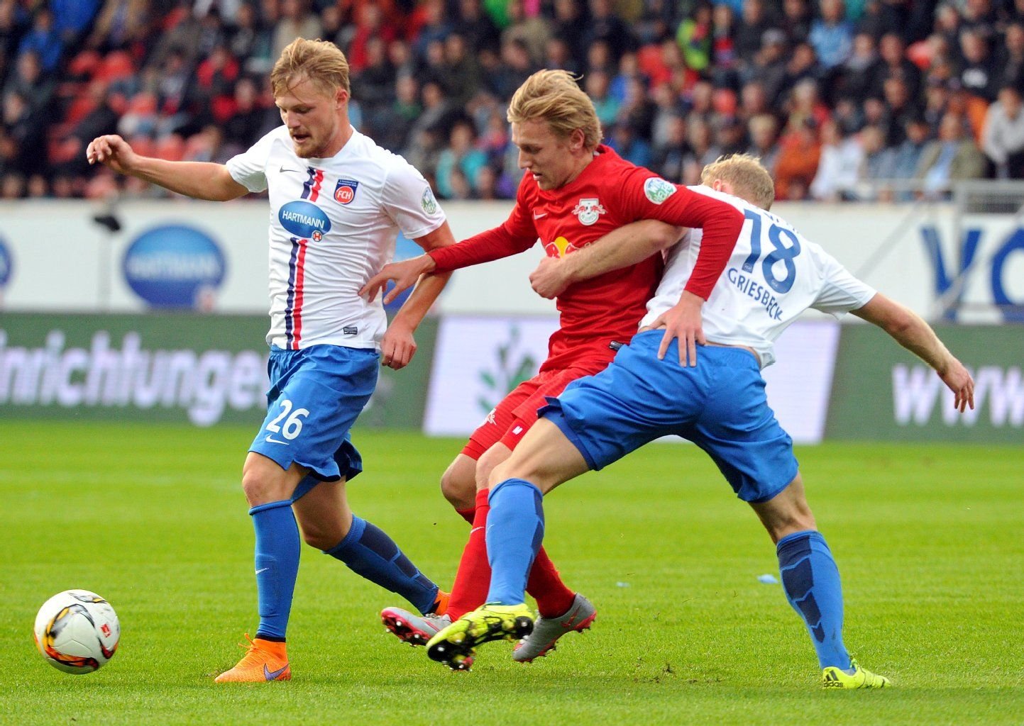 Heidenheims Arne Feick (l) und Sebastian Griesbeck kämpfen mit Emil Forsberg von Leipzig um den Ball.