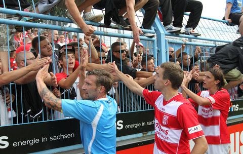 Die Hallenser Maik Wagefeld, Nils Pichinot und Philipp Zeiger feiern mit den HFC Fans. (FOTO: WORBSER)