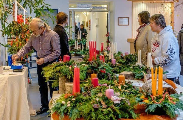 Gute Nachfrage herrschte wie immer nach Adventsgestecken. Rechts: Yasemine durfte die Kerzen dazu ziehen.