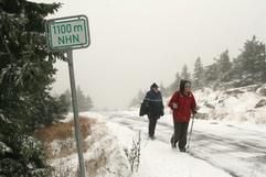 Zwei Wanderer sind am Mittwoch (01.11.2006) auf der verschneiten Brockenstraße unterwegs zum Brocken. (Foto: dpa)