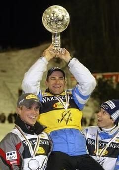 Ronny Ackermann (m) hebt den Pokal für den Gesamt-Weltcup in die Höhe. (Foto: dpa)