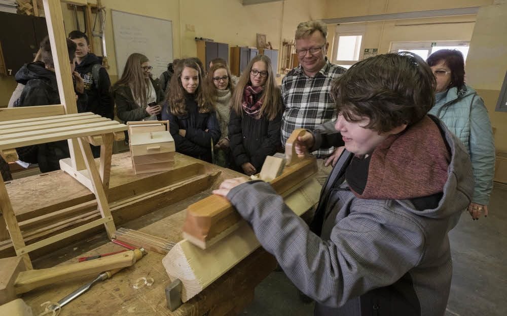 Paula Steinbrecher probiert in der Tischlerwerkstatt bei Ausbilder Steffen Ibe, mit einem Hobel eine Phase an ein Kantholz zu zaubern.