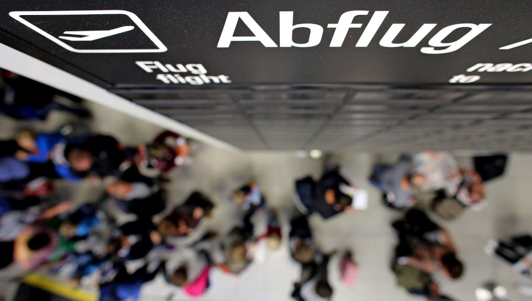 Flugreisende warten in einer Schlange vor der Sicherheitskontrolle auf dem Flughafen Leipzig/Halle.