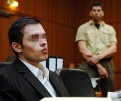 Der Angeklagte Jens Artur Al-M. (l.) im Prozess um den Mord an dem Millionärssohn Andreas Sascha Grimm wird am Freitag (23.09.2005) zu Prozessbeginn auf der Anklagebank des Landgerichts Frankfurt am Main von einem Justizbeamten beobachtet.