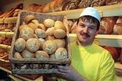 Lachend zeigt Bäcker Helmut Bernard am 31. Oktober 1996 einen Korb mit frischen Brötchen in seiner Backstube im thüringischen Adelshausen. (Archivfoto: dpa)