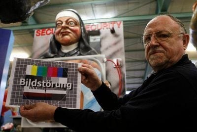 Wagendesigner Dieter Wenger vom Mainzer Carnevalsverein MCV zeigt in Mainz ein Bildstörungszeichen vor seinem Umzugswagen. (FOTO: DDP)