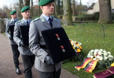 Bundeswehrsoldaten tragen die Orden der in Afghanistan gefallenen Soldaten für die Trauerfeier in die St. Lamberti-Kirche im niedersächsischen Selsingen. (FOTO: DPA)