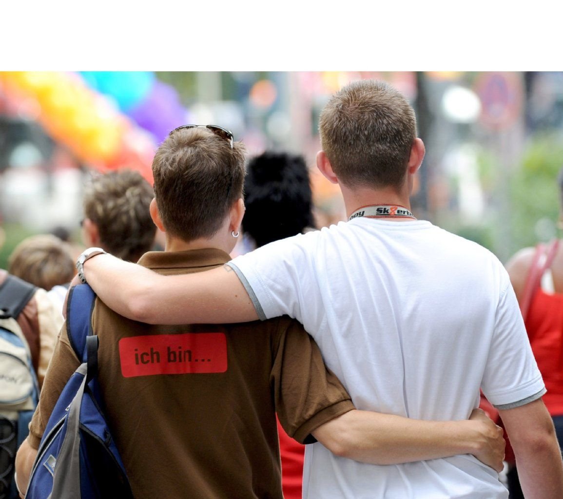 Ein schwules Paar läuft in Hamburg vor Beginn des Christopher Street Day über die Straße.