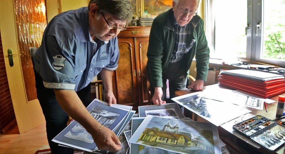 Dietrich Genau (rechts) sortiert mit Harald Albrecht seine Bilder.