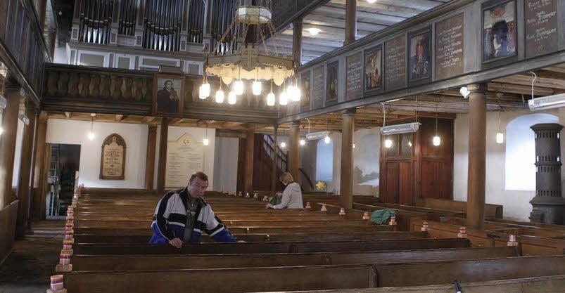 Gemeindemitglieder bereiten die Kirche für den Gottesdienst vor.